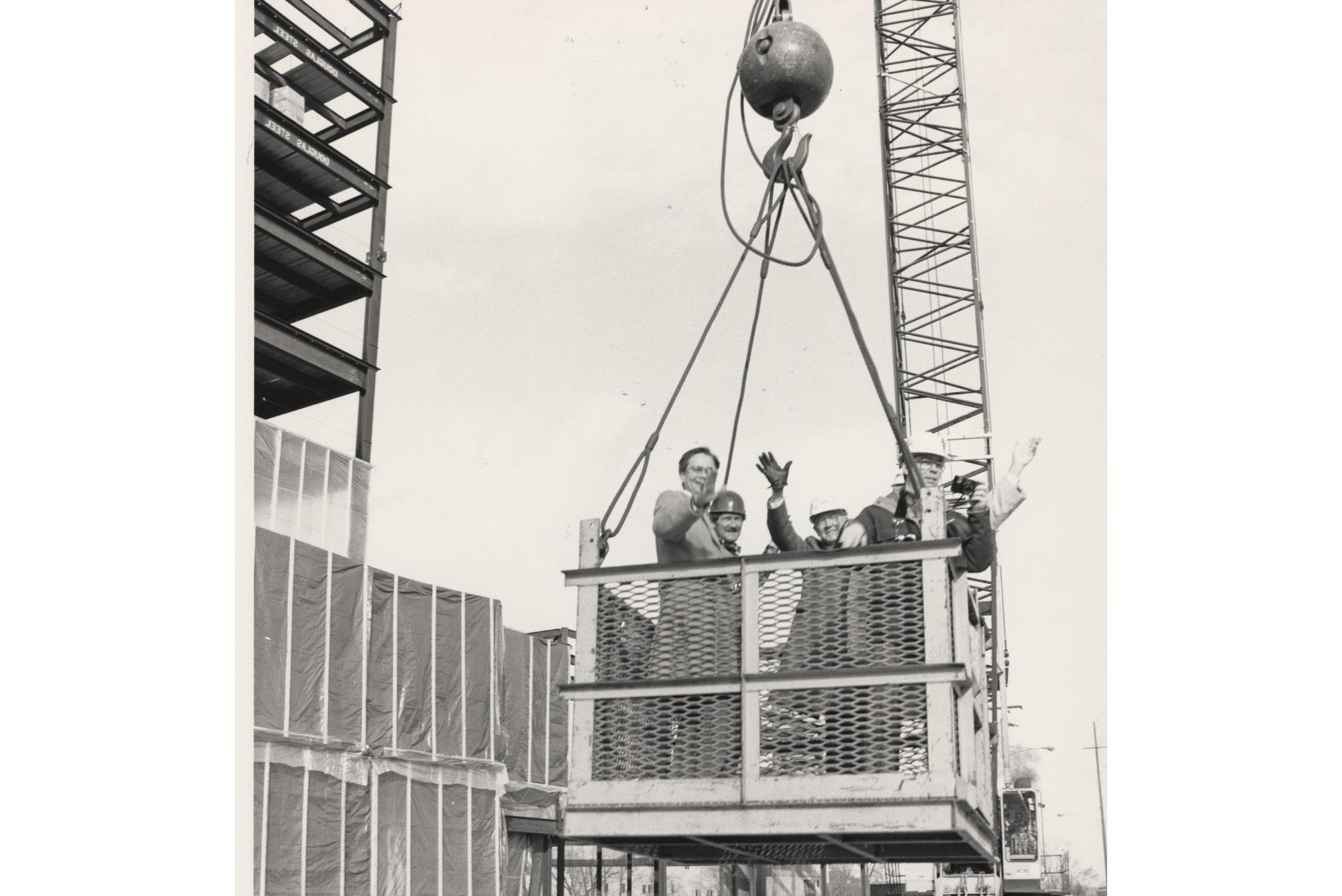 President Lubbers, waving, takes a trip to the top of Eberhard Center during the topping off ceremony.